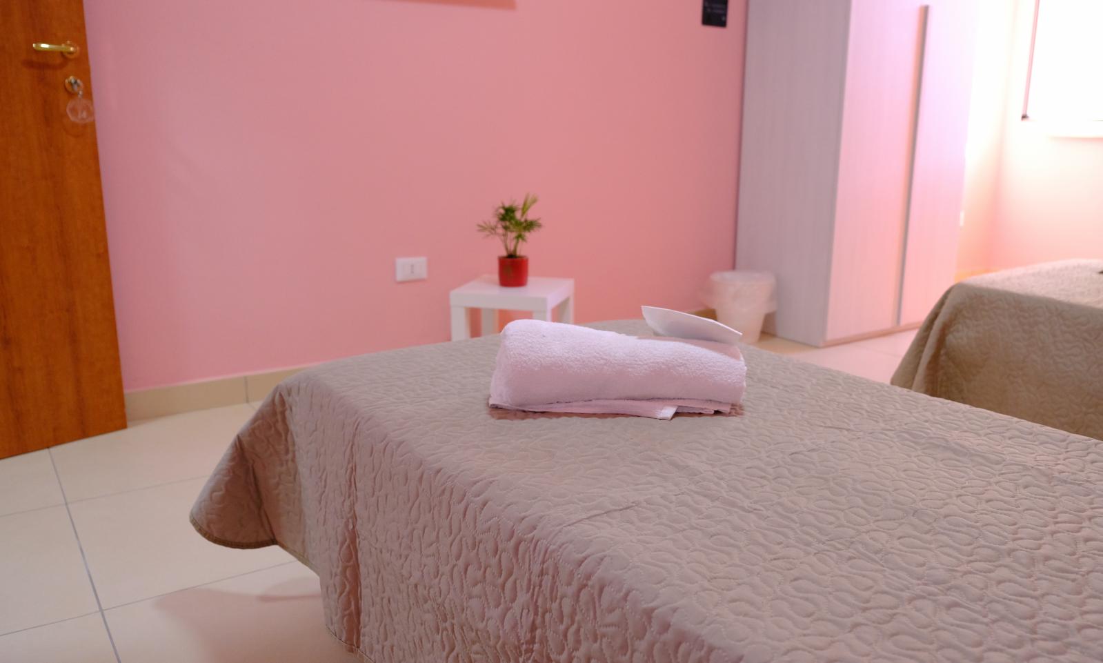 Dettaglio di camera con pareti rosa e letti negli alloggi Hermada