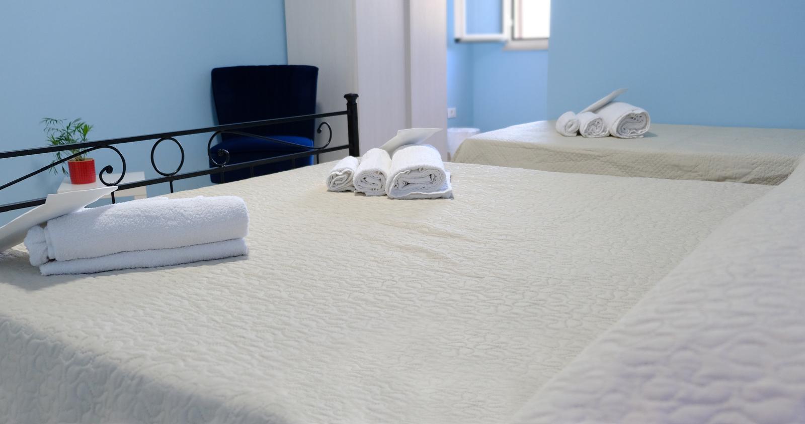 Dettaglio di camera con letto e asciugamani negli alloggi Hermada